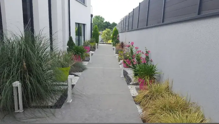Allée de jardin bordée de plantations et de galets