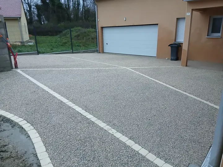 Cour extérieure terminée avec un revêtement minéral et des bordures pavées