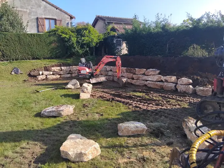 Construction en cours d'un muret paysager en pierre
