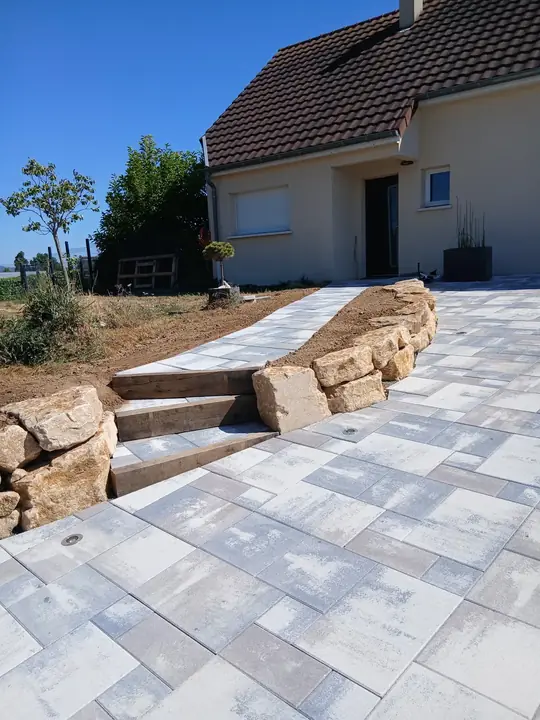 Escalier extérieur en pierre donnant sur une cour aménagée